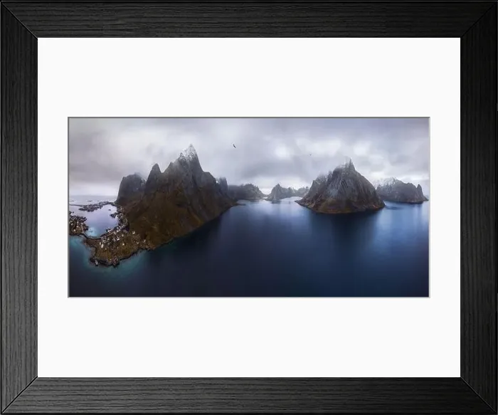 Framed Print : Aerial view of calm water of sea washing island with rocky formations under cloudy sky with small village in Rein Framed Print : Aerial view of calm water of sea washing island with rocky formations under cloudy sky with small village in Rein
