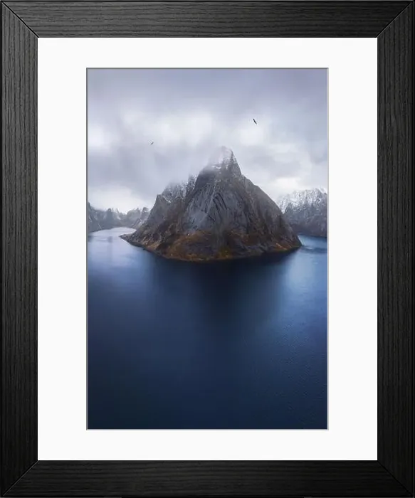 Framed Print : Aerial view of calm water of sea washing island with rocky formations covered in snow under cloudy sky Framed Print : Aerial view of calm water of sea washing island with rocky formations covered in snow under cloudy sky