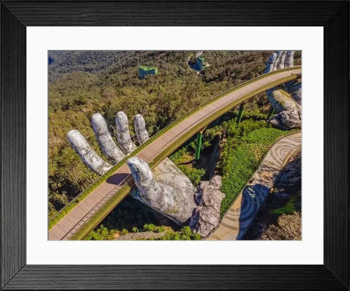 Framed Print : Top aerial view of the famous Golden Bridge is lifted by two giant hands in the tourist resort on Ba Na Hill in Da Nang Framed Print : Top aerial view of the famous Golden Bridge is lifted by two giant hands in the tourist resort on Ba Na Hill in Da Nang