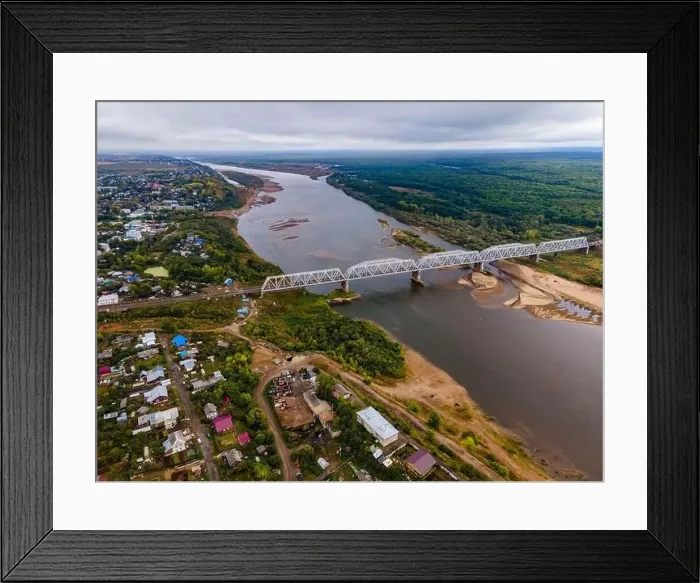 Framed Print : Bridge over river between trees and residential houses Framed Print : Bridge over river between trees and residential houses