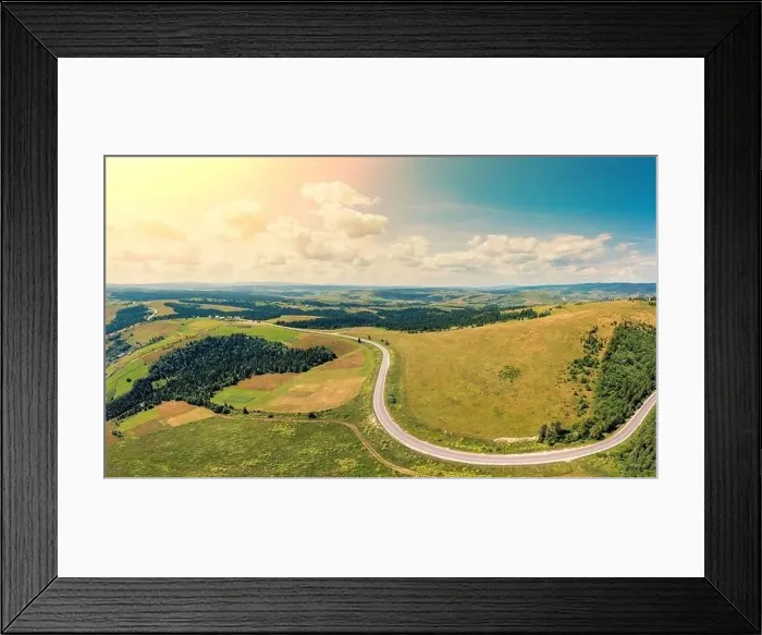 Framed Print : Panoramic aerial view of the countryside, country road, and cultivated and uncultivated fields in the hills Framed Print : Panoramic aerial view of the countryside, country road, and cultivated and uncultivated fields in the hills