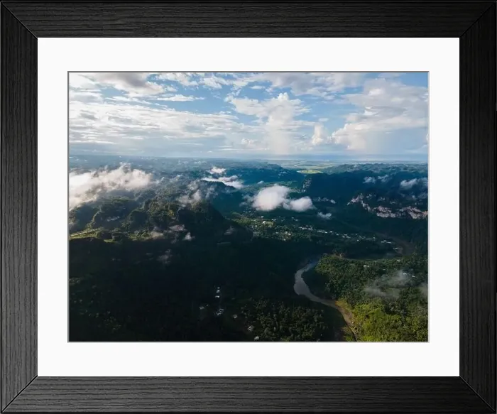 Framed Print : Aerial view of curving river flowing through rural settlement located on coast with dense woods in hilly valley Framed Print : Aerial view of curving river flowing through rural settlement located on coast with dense woods in hilly valley