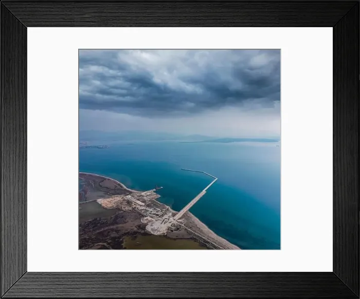Framed Print : Aerial view of a Construction of a marina from a drone with blue sea water and clouds on sky Framed Print : Aerial view of a Construction of a marina from a drone with blue sea water and clouds on sky