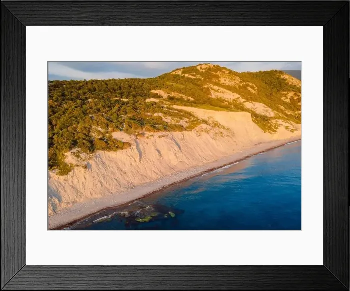 Framed Print : Aerial view of coastline with cliff, trees and quiet sea. Coastline with sunset colors