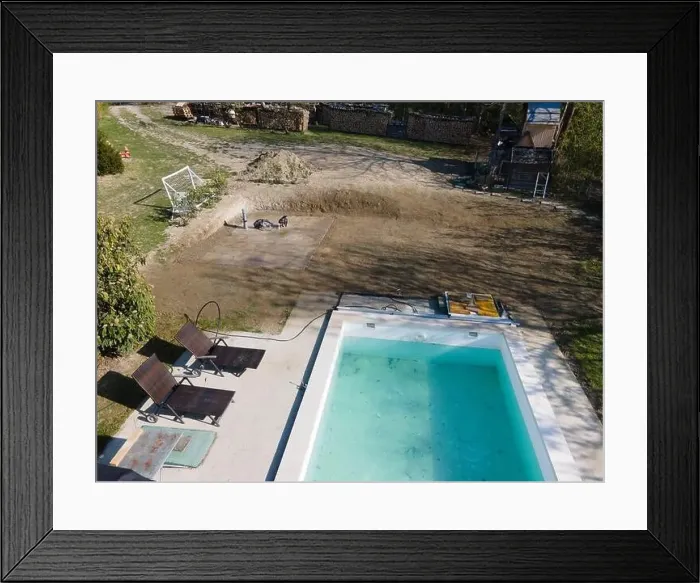 Framed Print : Drone flight over fresh earth area with grass grown next to pool construction site in April