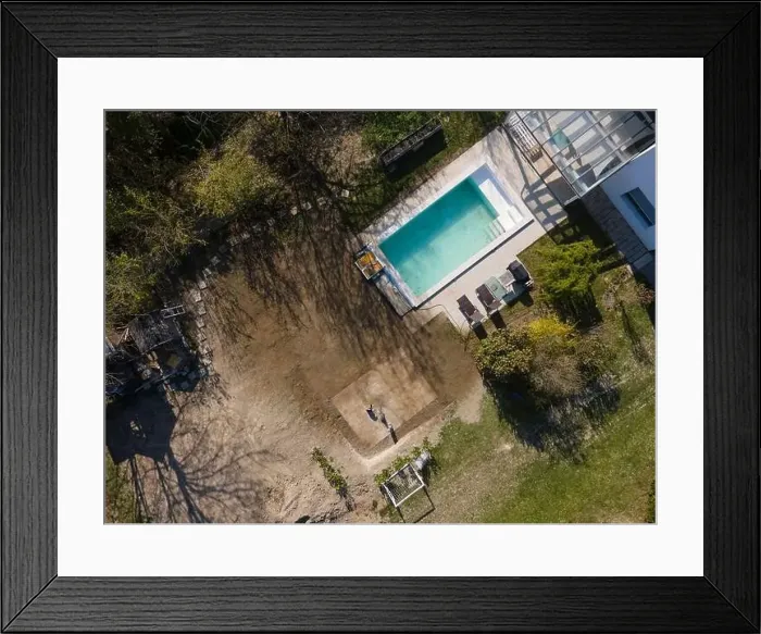Framed Print : Drone flight over fresh earth area with grass grown next to pool construction site in April Framed Print : Drone flight over fresh earth area with grass grown next to pool construction site in April