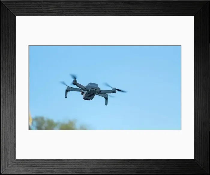 Framed Print : Consumer drone with camera hovering against sky with copy space Framed Print : Consumer drone with camera hovering against sky with copy space