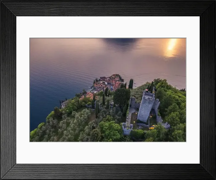 Framed Print : Aerial view of Vezio Castle and Varenna village in background during summer sunset Framed Print : Aerial view of Vezio Castle and Varenna village in background during summer sunset