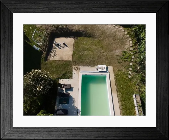 Framed Print : Drone flight over pool in the middle of greenery, fresh grass grown and the pool is not yet cleaned Framed Print : Drone flight over pool in the middle of greenery, fresh grass grown and the pool is not yet cleaned
