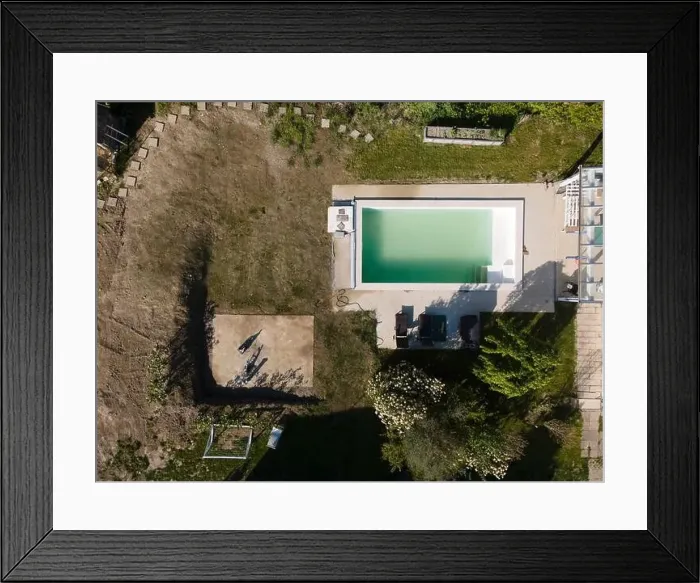Framed Print : Drone flight over pool in the middle of greenery, fresh grass grown and the pool is not yet cleaned Framed Print : Drone flight over pool in the middle of greenery, fresh grass grown and the pool is not yet cleaned
