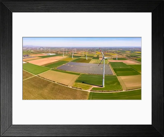 Framed Print : Huge wind turbines between agricultural land and a solar park in a rural area from a drone view, Germany Framed Print : Huge wind turbines between agricultural land and a solar park in a rural area from a drone view, Germany