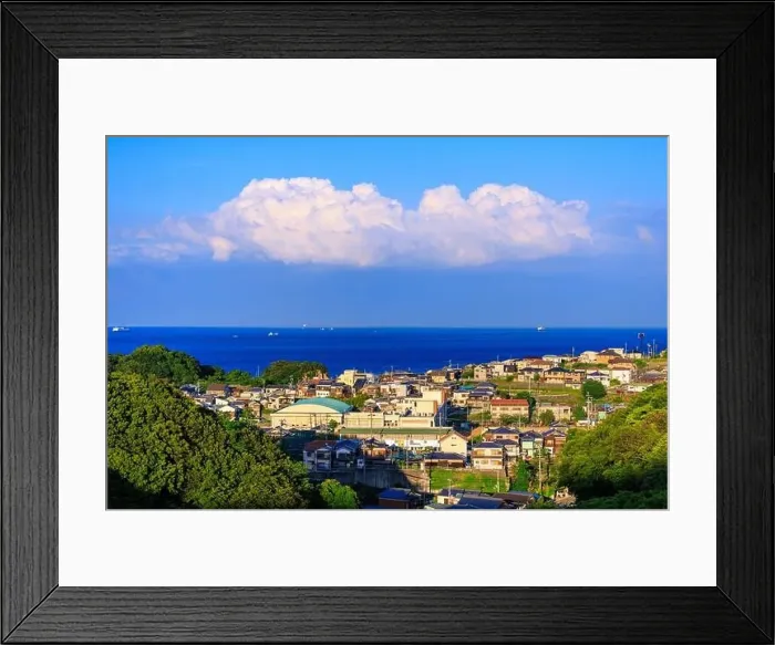 Framed Print : Afternoon sun hits small coastal village as clouds billow in distance Framed Print : Afternoon sun hits small coastal village as clouds billow in distance