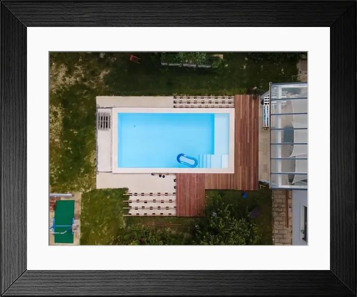 Framed Print : Drone flight over beautiful green garden with pool and the wooden terrace of the pool is currently in progress Framed Print : Drone flight over beautiful green garden with pool and the wooden terrace of the pool is currently in progress