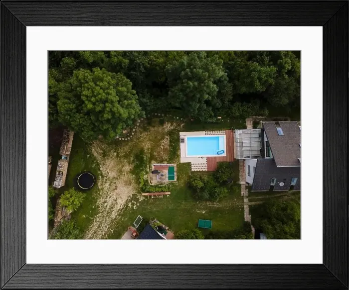 Framed Print : Drone flight over beautiful green garden with pool and the wooden terrace of the pool is currently in progress