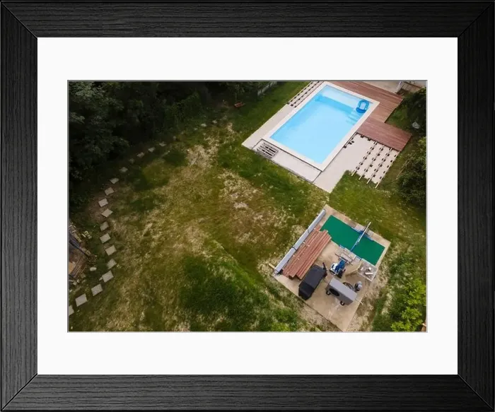 Framed Print : Drone flight over beautiful green garden with pool and the wooden terrace of the pool is currently in progress Framed Print : Drone flight over beautiful green garden with pool and the wooden terrace of the pool is currently in progress