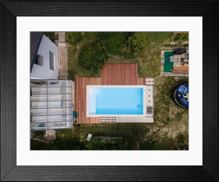 Framed Print : aerial drone flight over beautiful green garden with pool and the wooden deck of the pool is in progress Framed Print : aerial drone flight over beautiful green garden with pool and the wooden deck of the pool is in progress