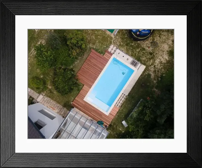 Framed Print : aerial drone flight over beautiful green garden with pool and the wooden deck of the pool is in progress Framed Print : aerial drone flight over beautiful green garden with pool and the wooden deck of the pool is in progress