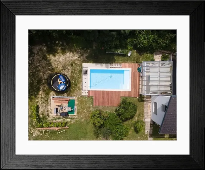 Framed Print : aerial drone flight over beautiful green garden with pool and the wooden deck of the pool is in progress Framed Print : aerial drone flight over beautiful green garden with pool and the wooden deck of the pool is in progress
