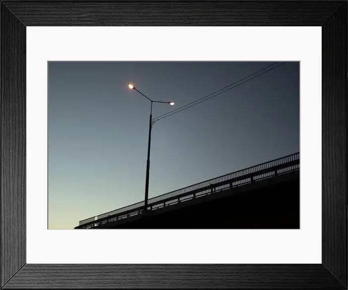 Framed Print : Evening view of track. Cityscape. Chaus at sunset. Poles with lamps along road Framed Print : Evening view of track. Cityscape. Chaus at sunset. Poles with lamps along road