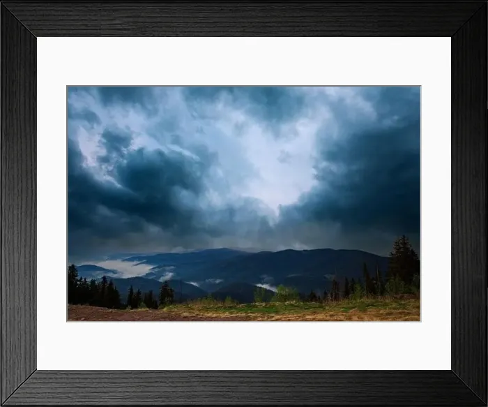 Framed Print : Cold cloudy rainy weather over low hills covered with spruce evergreen forests in Rhodope Mountains against backdrop of