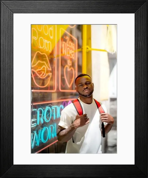 Framed Print : Young man wearing casual clothing in front of neon lights on window Framed Print : Young man wearing casual clothing in front of neon lights on window