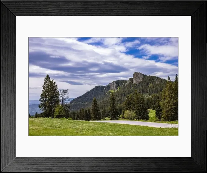 Framed Print : A winding asphalt intermountain road passes high green hills covered with spruce forests Framed Print : A winding asphalt intermountain road passes high green hills covered with spruce forests