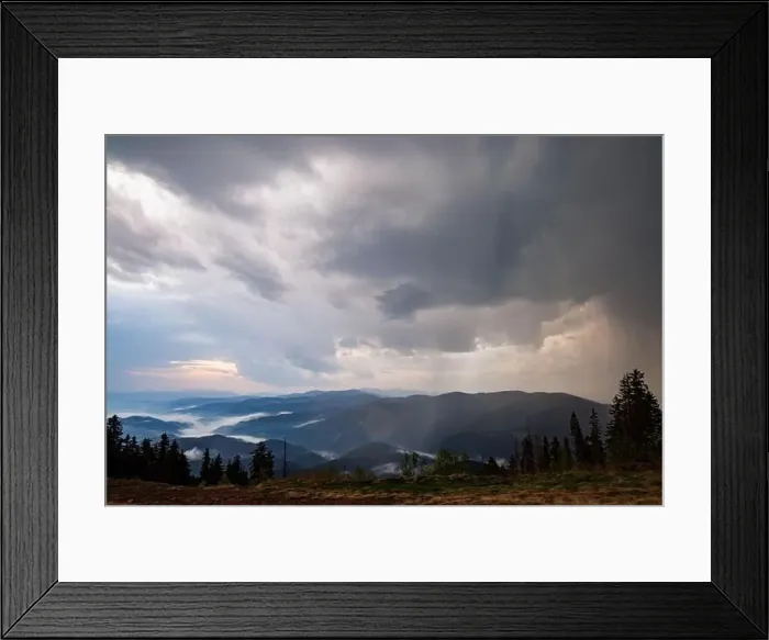 Framed Print : Cold cloudy rainy weather over low hills covered with spruce evergreen forests in Rhodope Mountains against backdrop of