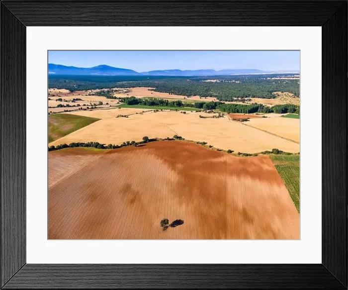 Framed Print : Rural landscape of harvested fields and mountains in the background in summer day Framed Print : Rural landscape of harvested fields and mountains in the background in summer day