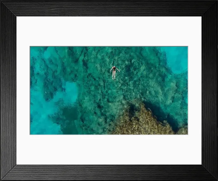Framed Print : Aerial view of mediterranean sea bay with a girl swimming in the middle Framed Print : Aerial view of mediterranean sea bay with a girl swimming in the middle