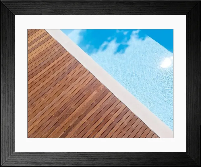 Framed Print : Drone flight over pool with nice wooden terrace surrounded by green lawn in beautiful garden