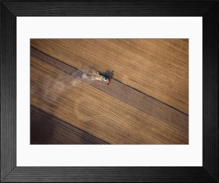 Framed Print : Agricultural machines harvest wheat in the field. Aerial shot from above. There is a lot of dust around the harvester Framed Print : Agricultural machines harvest wheat in the field. Aerial shot from above. There is a lot of dust around the harvester