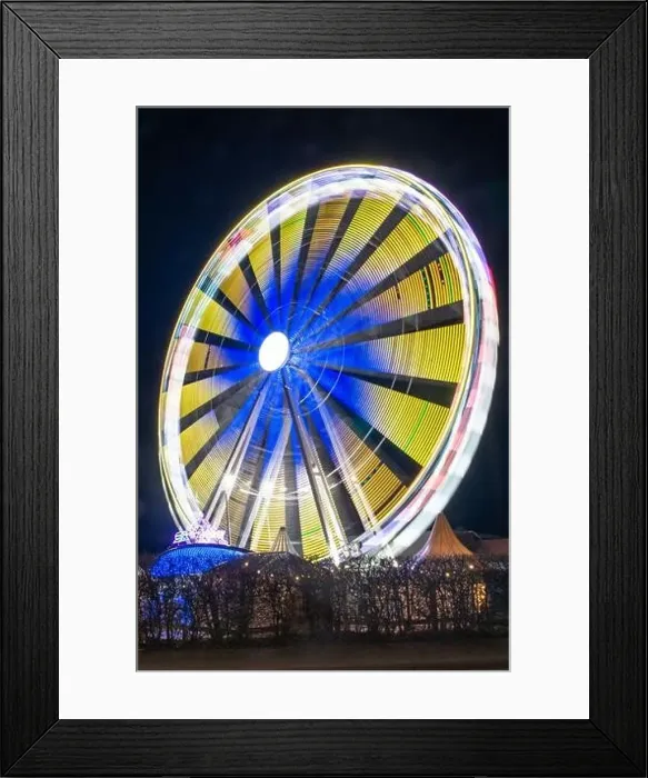 Framed Print : A vertical shot of a Ferris wheel with bright blurry neon lights shining from it at night Framed Print : A vertical shot of a Ferris wheel with bright blurry neon lights shining from it at night