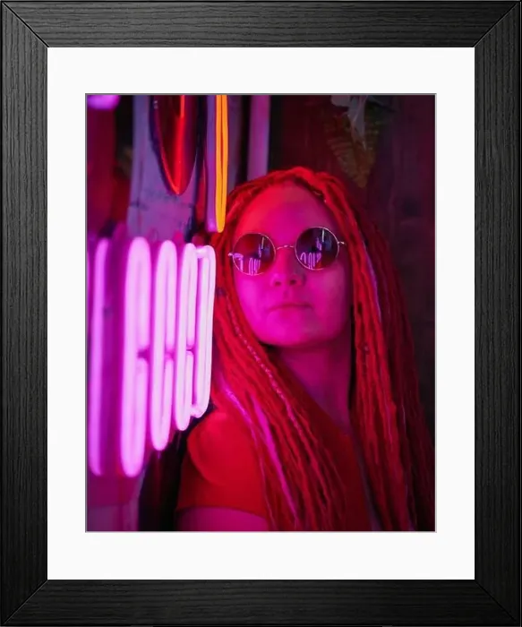 Framed Print : Girl in neon lights, beautiful woman in sunglasses, with pink hair, with dreadlocks pigtails