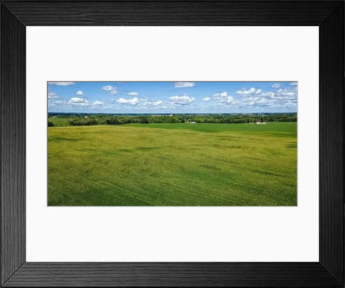 Framed Print : A cloudy blue sky extends to the horizon with a massive farm field below surrounded by a rural area in Wisconsin Framed Print : A cloudy blue sky extends to the horizon with a massive farm field below surrounded by a rural area in Wisconsin
