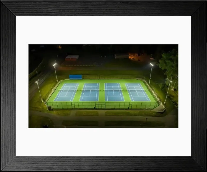 Framed Print : Evening aerial video of outdoor blue tennis courts with pickleball lines with lights turned on Framed Print : Evening aerial video of outdoor blue tennis courts with pickleball lines with lights turned on