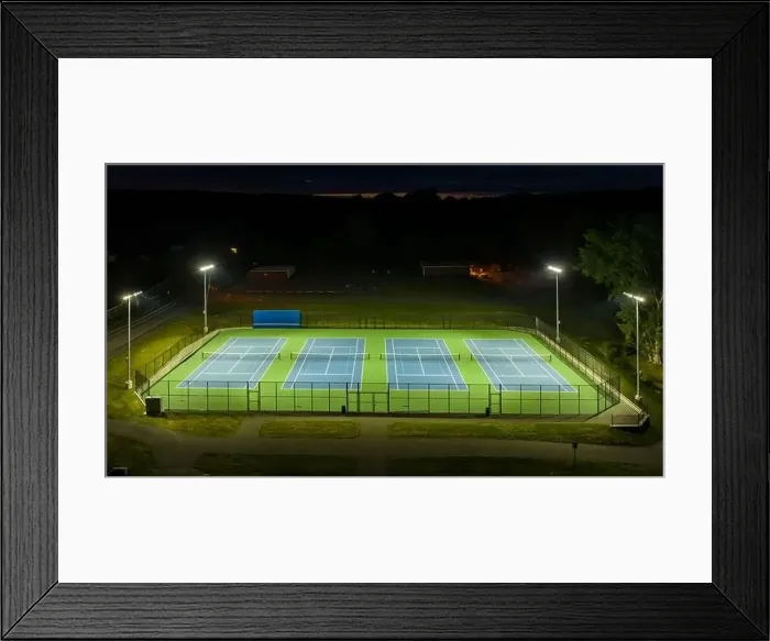 Framed Print : Evening aerial video of outdoor blue tennis courts with pickleball lines with lights turned on Framed Print : Evening aerial video of outdoor blue tennis courts with pickleball lines with lights turned on