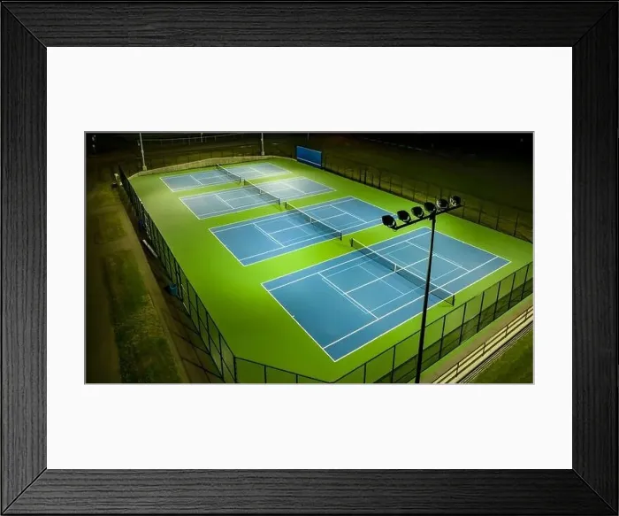 Framed Print : Evening aerial video of outdoor blue tennis courts with pickleball lines with lights turned on Framed Print : Evening aerial video of outdoor blue tennis courts with pickleball lines with lights turned on