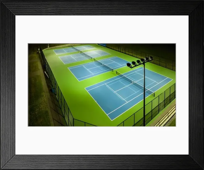 Framed Print : Evening aerial video of outdoor blue tennis courts with pickleball lines with lights turned on Framed Print : Evening aerial video of outdoor blue tennis courts with pickleball lines with lights turned on