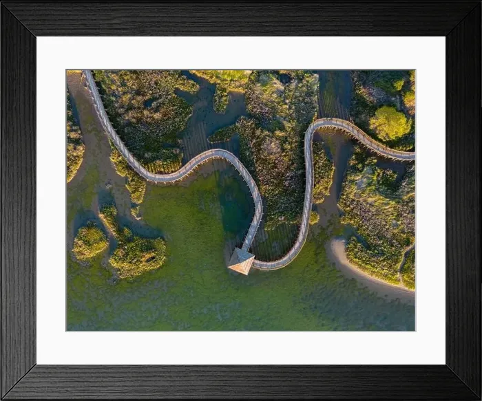 Framed Print : Top view of sea with wooden walkway - Aerial top view of wooden bridge pathway over marshy river with vegetation
