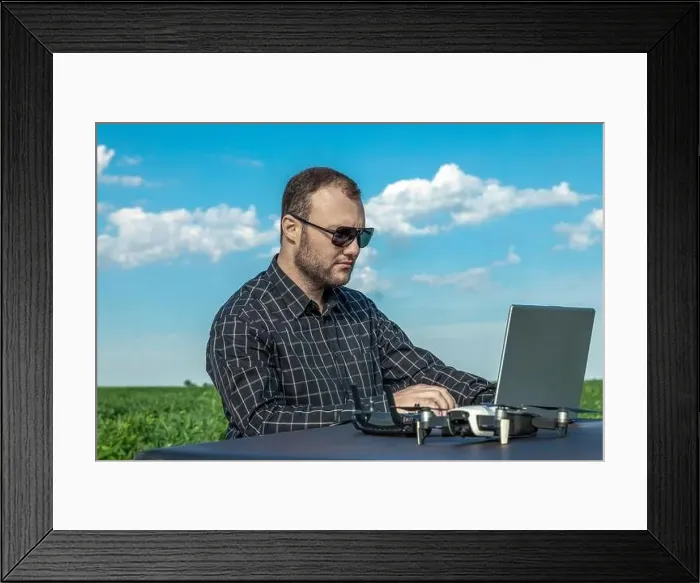 Framed Print : Farmer standing in soybean field looking at notebook and drone Framed Print : Farmer standing in soybean field looking at notebook and drone
