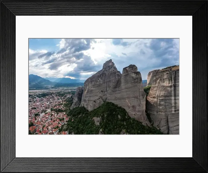 Framed Print : Meteora Greece. Blue sky with clouds over Monastery buildings on top of rocks and Kalambaka town and valley