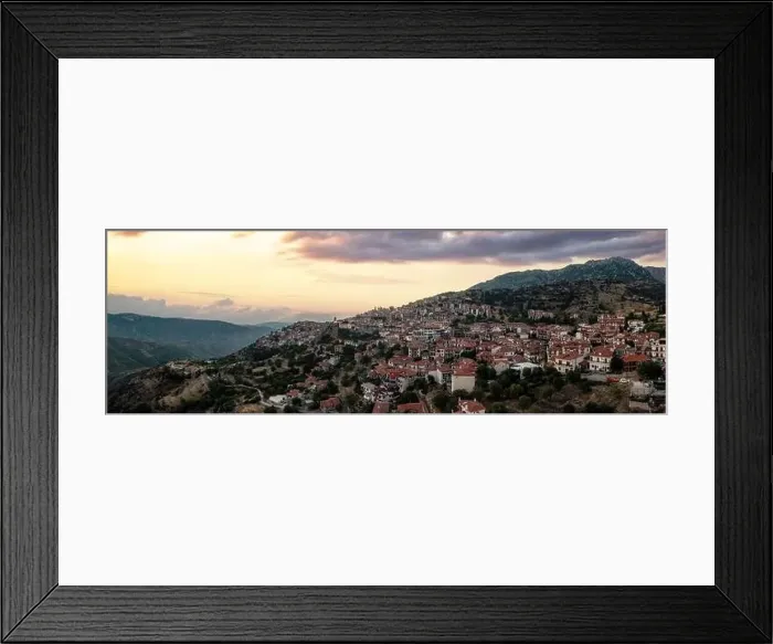 Framed Print : Arachova Greece mountain town aerial panoramic view. Traditional houses and stone tower clock cloudy sky at sunset