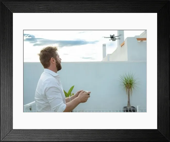 Framed Print : Man controlling drone in outdoors image with remote control Framed Print : Man controlling drone in outdoors image with remote control
