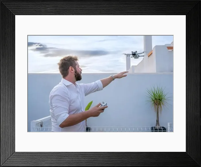 Framed Print : Man controlling drone in outdoors image with remote control Framed Print : Man controlling drone in outdoors image with remote control