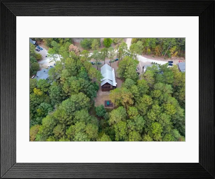 Framed Print : Aerial view of cottages and cars parked nearby in the woods among green trees Framed Print : Aerial view of cottages and cars parked nearby in the woods among green trees