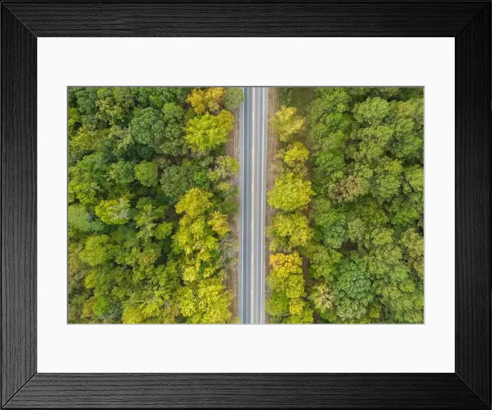 Framed Print : Aerial view from above of country road through the green summer forest in Autumn Framed Print : Aerial view from above of country road through the green summer forest in Autumn