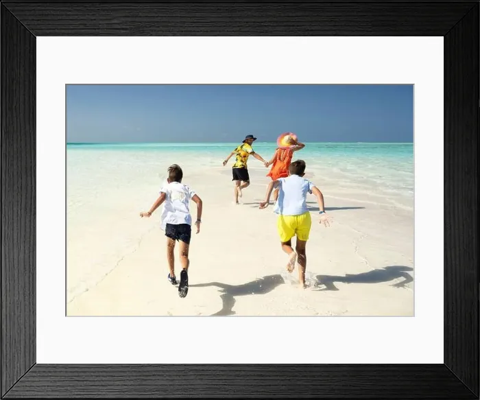 Framed Print : a family plays and has fun on a strip of sand during a splendid sunny day Framed Print : a family plays and has fun on a strip of sand during a splendid sunny day