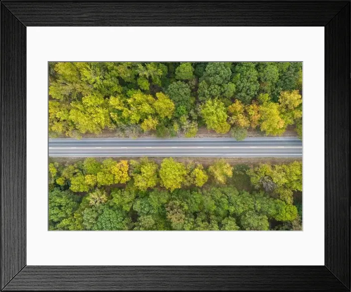 Framed Print : Aerial view from above of country road through the green summer forest in Autumn Framed Print : Aerial view from above of country road through the green summer forest in Autumn