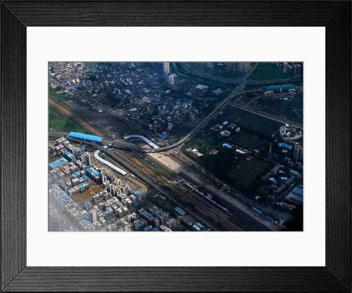 Framed Print : An aerial view of Mumbai's skyline passing over a building with roads and bridges Framed Print : An aerial view of Mumbai's skyline passing over a building with roads and bridges