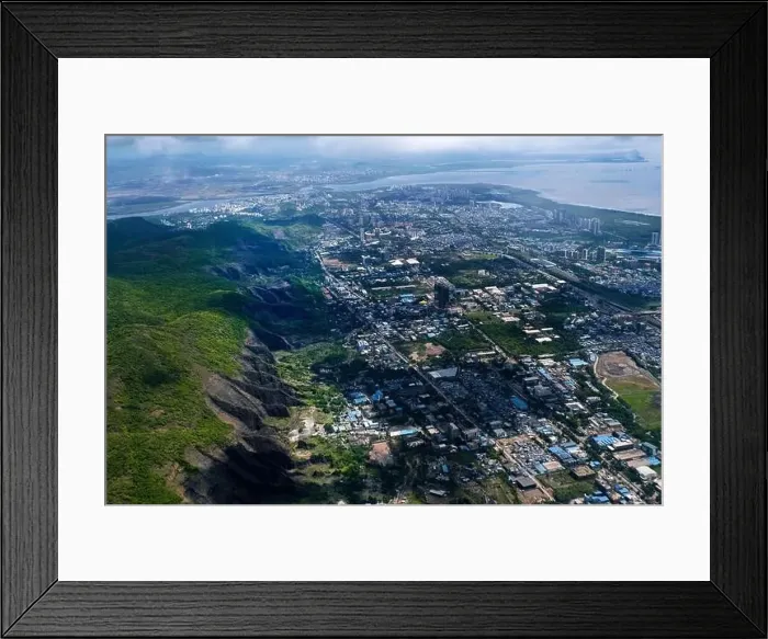 Framed Print : An aerial view of Mumbai's skyline passing over a building with roads and bridges